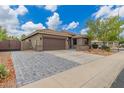 Beautiful home showcasing a two-car garage, desert landscaping, and charming brick driveway at 2111 E Yellowstone Pl, Chandler, AZ 85249