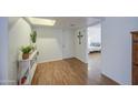 Bright entryway featuring wood floors, neutral walls, and view of a bedroom at 2505 E Desert Cactus St, Phoenix, AZ 85032