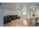 Open living room featuring wood floors, neutral paint, and a comfortable sectional sofa at 2505 E Desert Cactus St, Phoenix, AZ 85032
