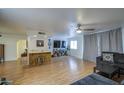 Spacious living room featuring wood laminate floors, a modern ceiling fan, and a cozy seating area at 2505 E Desert Cactus St, Phoenix, AZ 85032