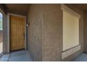 Covered front porch featuring a wood door with a digital keypad and textured walls at 29058 N Cactus Cir, San Tan Valley, AZ 85143