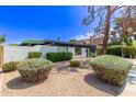 Mid-century modern home with white brick facade and lush, green landscaping for added curb appeal at 3710 E Altadena Ave, Phoenix, AZ 85028