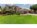 Charming home featuring a manicured lawn, desert landscaping, and an attached two-car garage at 453 E Baylor Ln, Gilbert, AZ 85296