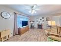 Bright living room featuring wood-look floors, a large window, and a decorative display shelf at 5410 E University Dr, Mesa, AZ 85205