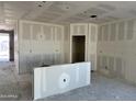 The unfinished living room reveals blank drywall, pre-installed utilities, and a bright window showcasing construction at 5515 W Piedmont Rd, Laveen, AZ 85339