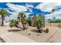 Beautiful home showcasing desert landscaping with palm trees, cacti, and a concrete driveway at 5526 N 77Th Way, Scottsdale, AZ 85250