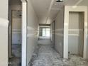 Hallway displaying unfinished drywall and providing access to various rooms, with natural light entering from the exterior at 5610 W Hopi Trl, Laveen, AZ 85339
