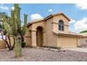 Two-story home with arched entryway and double garage, complemented by desert landscaping with native cacti at 6516 E Rochelle St, Mesa, AZ 85215