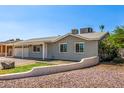 Well-maintained home with a two-car garage, complemented by desert landscaping at 7047 W Almeria Rd, Phoenix, AZ 85035