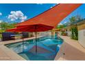 A private in-ground pool offering a refreshing escape, complete with shade structures and well-maintained decking at 7102 E Kalil Dr, Scottsdale, AZ 85254