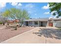 Charming single-story home featuring desert landscaping, ample driveway, and a covered porch at 818 W Earll Dr, Phoenix, AZ 85013