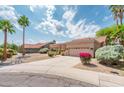 Inviting single-story home with desert landscaping, mature palm trees, and a two-car garage at 8977 E Ludlow Dr, Scottsdale, AZ 85260