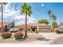 Charming single-story home with desert landscaping, mature palm trees, and a two-car garage at 8977 E Ludlow Dr, Scottsdale, AZ 85260