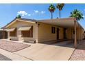 Single-story home featuring a covered carport for parking and desert landscaping at 9302 E Broadway Rd # 45, Mesa, AZ 85208