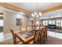 Formal dining area features a glass table, chandelier, and adjacent living spaces at 9952 W Jessie Ln, Peoria, AZ 85383
