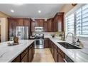 Modern kitchen features stainless steel appliances, dark wood cabinets, and white countertops at 9952 W Jessie Ln, Peoria, AZ 85383