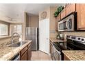 Well-lit kitchen with granite countertops, stainless steel appliances and wooden cabinetry at 1130 E Ferrara St, San Tan Valley, AZ 85140