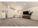 Spacious living room with plush carpeting, vaulted ceilings, and a large window, creating a bright and airy atmosphere at 1421 E Charleston Ave, Phoenix, AZ 85022
