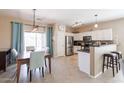 Bright kitchen featuring stainless steel appliances, white cabinets and dining area at 1461 W Brangus Way, San Tan Valley, AZ 85143