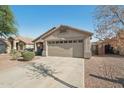 View of the two-car garage and the driveway of this lovely single-story home at 15453 W Shangri La Rd, Surprise, AZ 85379
