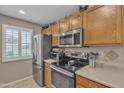 Well-equipped kitchen with stainless steel appliances, wood cabinets, and ample counter space at 15470 W Mauna Loa Ln, Surprise, AZ 85379