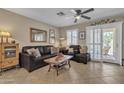 Cozy living room featuring comfortable seating, tile flooring, and natural light through window at 15470 W Mauna Loa Ln, Surprise, AZ 85379