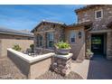Cozy front patio with stone accents, two chairs, and potted plants for relaxed outdoor living at 16772 W Cypress St, Goodyear, AZ 85395