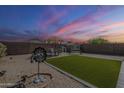 Spacious backyard featuring a grassy area, patio furniture, a decorative windmill, and privacy fence at 1769 E Jacob St, San Tan Valley, AZ 85140