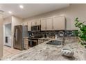 This kitchen features stainless steel appliances, granite countertops, tile backsplash, and light wooden cabinets at 205 N 74Th St # 166, Mesa, AZ 85207