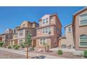 Inviting front exterior showcases a three-story home, tiled roof, stone accents, neat landscaping, and a cozy patio area at 2118 N 77Th Ln, Phoenix, AZ 85035