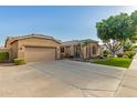 Tan home with a two-car garage, well kept front yard, desert landscaping, and extended concrete driveway at 2183 W Hawken Way, Chandler, AZ 85286