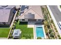 Drone shot of a beautiful backyard, including a sparkling pool, play area and covered patio, and solar panels at 22721 N 34Th St, Phoenix, AZ 85050
