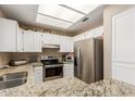 Bright kitchen featuring granite countertops, stainless steel appliances, and ample white cabinets at 2941 N Oregon St # 12, Chandler, AZ 85225