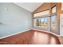 Bright living room featuring hardwood floors, a vaulted ceiling, and large windows at 3905 S Bridal Vail Dr, Gilbert, AZ 85297