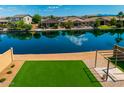 Waterfront backyard featuring artificial turf and a scenic view of the surrounding neighborhood at 40445 W Bravo Dr, Maricopa, AZ 85138