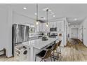 Bright kitchen featuring a large island with seating, pendant lighting, and stainless steel appliances at 40445 W Bravo Dr, Maricopa, AZ 85138