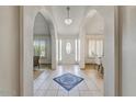 Bright foyer featuring arched entryways, tiled floor with a mosaic design, and a decorative light fixture at 5710 E Anderson Dr, Scottsdale, AZ 85254