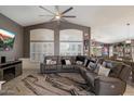 Spacious living room features a ceiling fan, a large sectional sofa, and custom window shutters at 7925 E Osage Ave, Mesa, AZ 85212