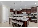 Kitchen featuring a spacious island with seating, stainless steel appliances, and modern lighting at 794 W Leatherwood Ave, Queen Creek, AZ 85140