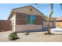 Charming home featuring stone facade and a well-maintained desert landscaped front yard at 9025 W Crown King Rd, Tolleson, AZ 85353
