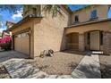Exterior shot of the house showing the tan stucco, garage, and covered porch with stone supports at 973 E Corral St, Avondale, AZ 85323