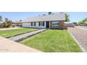 Home featuring an expansive green lawn and landscaped walkway to the front door at 1021 S Almar Cir, Mesa, AZ 85204