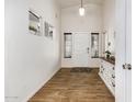 Bright entryway with wood-look tile flooring, white walls, and a console table with decorative accents at 12374 W Hopi St, Avondale, AZ 85323