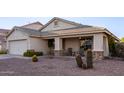 Inviting home featuring a covered front porch with seating and low-maintenance desert landscaping at 12374 W Hopi St, Avondale, AZ 85323