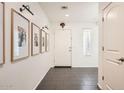 Inviting entryway featuring dark wood-look flooring, crisp white walls, and modern lighting fixtures at 128 E Bluejay Dr, Chandler, AZ 85286