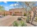 Attractive home exterior with desert landscaping highlighting the three-car garage and desert foliage at 13450 E Via Linda -- # 2022, Scottsdale, AZ 85259