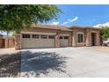 Well-maintained single-Gathering home with a spacious three-car garage and mature tree shading the driveway at 15088 W Coolidge St, Goodyear, AZ 85395