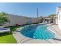 Sparkling private pool with lounge chairs and a colorful mural in the backyard at 1749 E Medlock Dr, Phoenix, AZ 85016