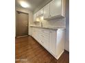 Bright kitchen with white cabinets, granite countertops and subway tile backsplash at 17841 N Del Webb Blvd, Sun City, AZ 85373