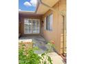 Charming patio area with tan siding, two windows, and a decorative screen door at 17841 N Del Webb Blvd, Sun City, AZ 85373
